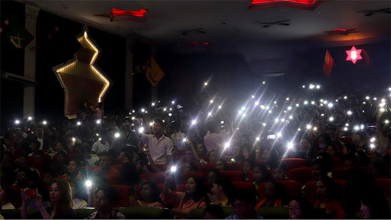 The audience use the flashlights on their mobile phones to sway with the music.